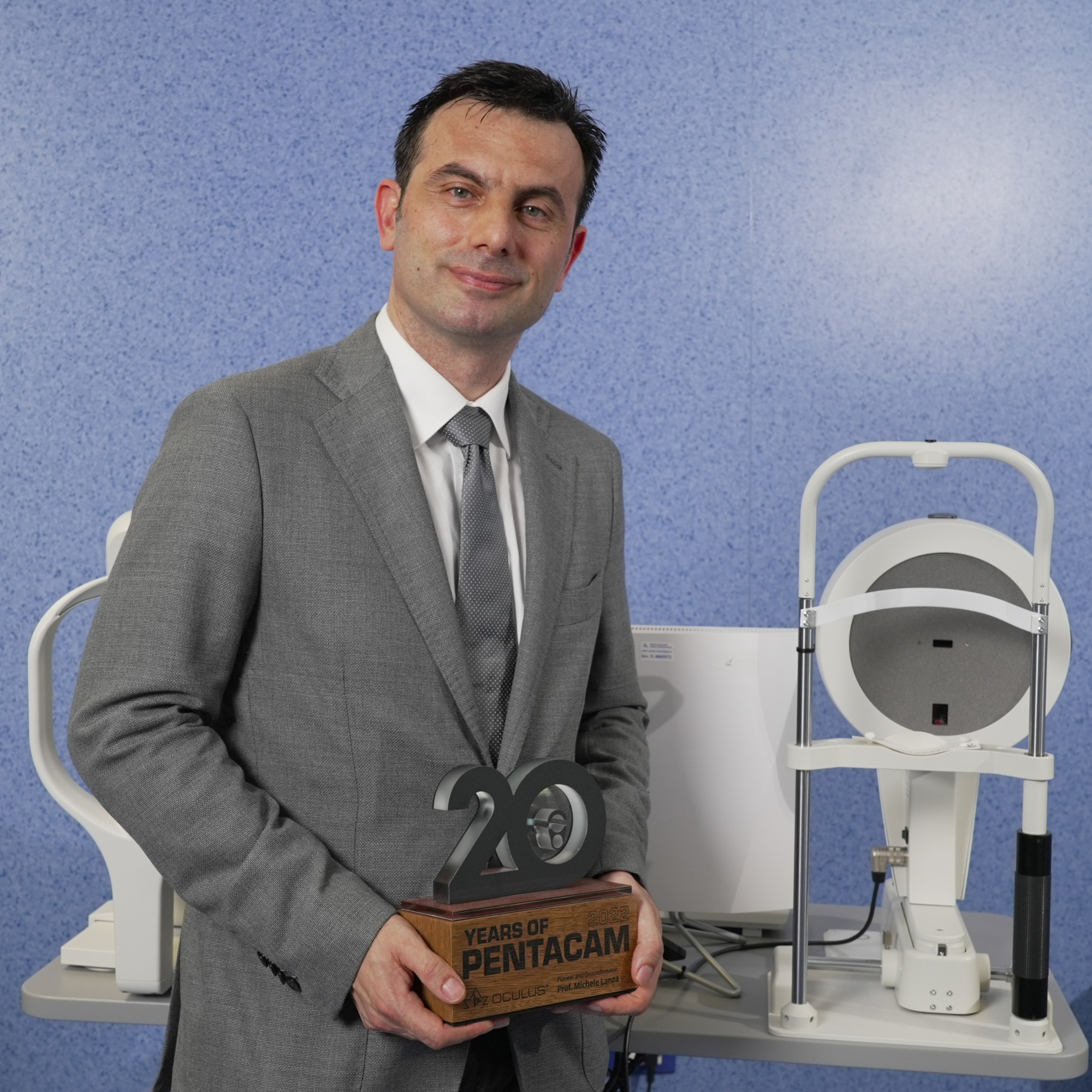 Prof Michele Lanza holding his 20th Anniversary Pentacam® Trophy